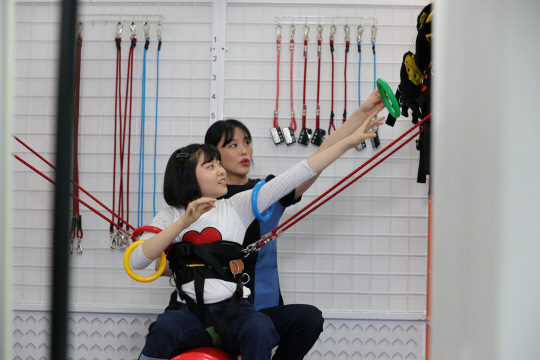 푸르메재단 관계자가 넥슨어린이재활병원 어린이의 재활을 위해 물리치료를 하고 있다. HD현대1%나눔재단 제공